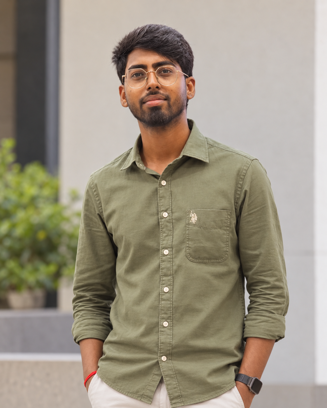 Anmol Patel in an olive shirt, standing in a courtyard